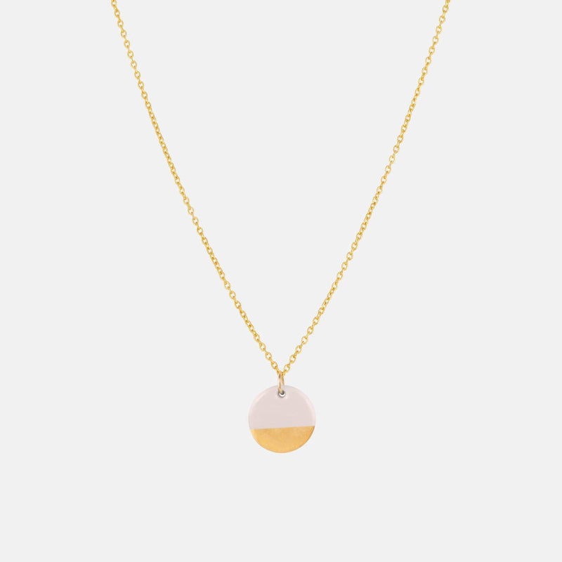 Necklace with a round pendant on a light pink background