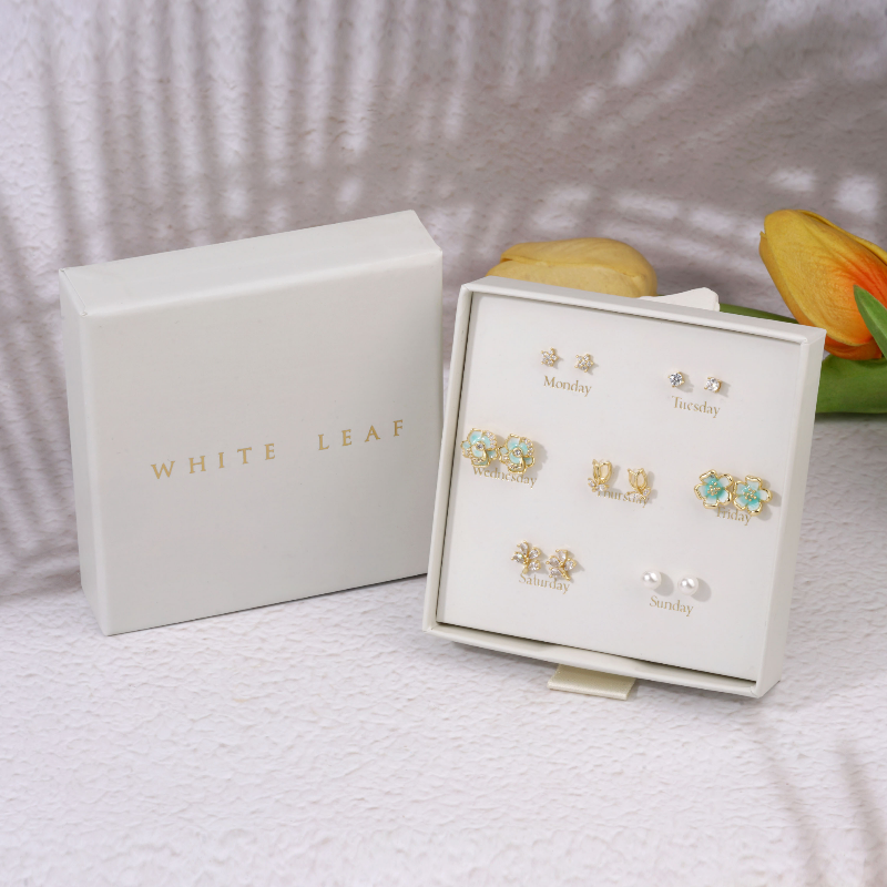 Jewelry set with 'White Leaf' box on a textured surface