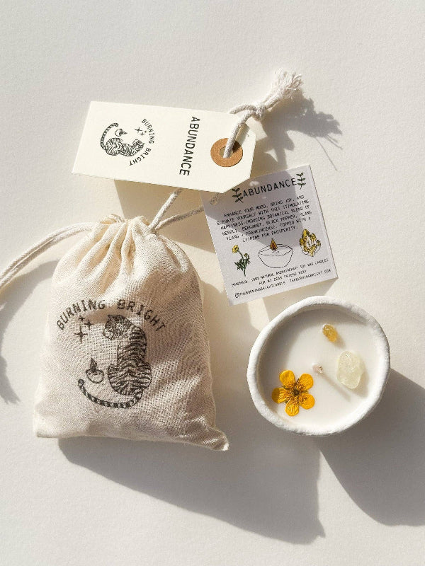 Candle kit with a drawstring bag, candle, and packaging on a light background