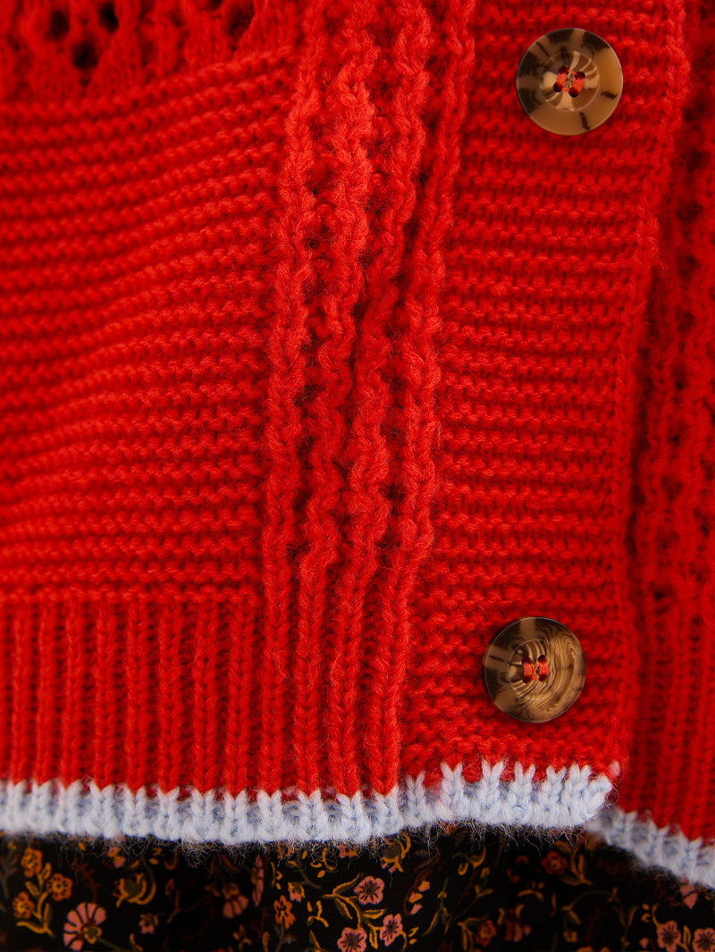 Close-up of a red knitted garment with button details