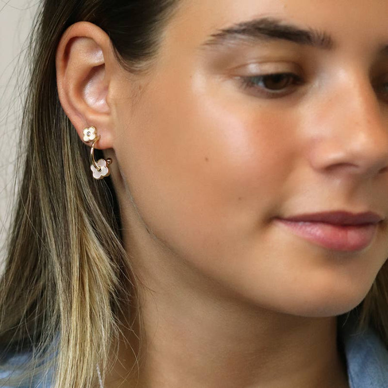 Close-up of a woman wearing floral earrings with a neutral background
