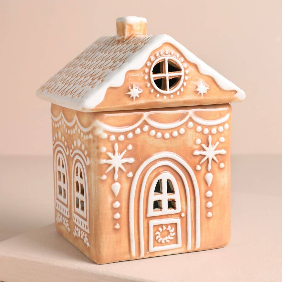 Decorative gingerbread house-shaped container on a beige background