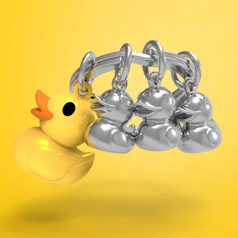 Silver keyring with silver duck charms and a yellow rubber duck on a yellow background