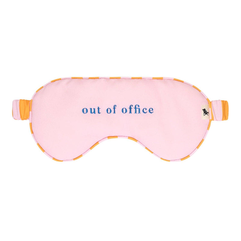 Pink sleep mask with 'out of office' text on a white background