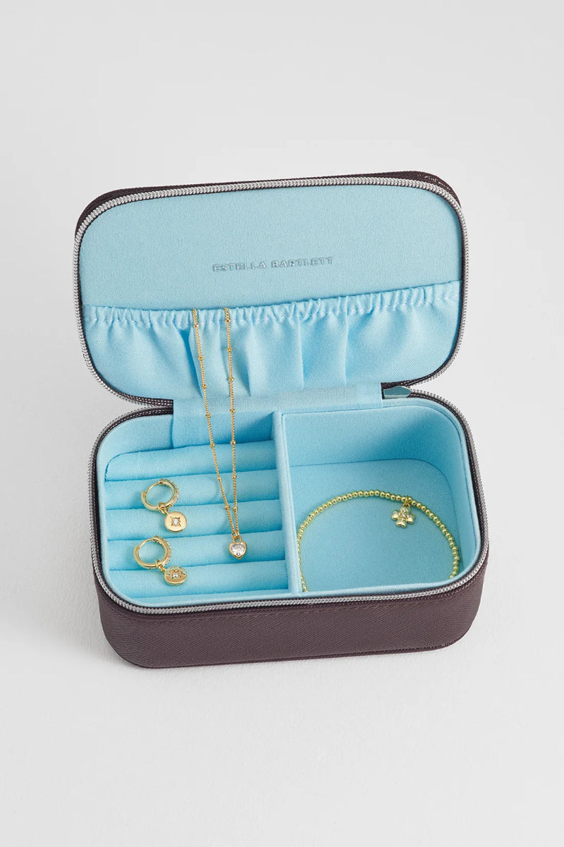 Jewelry case with gold necklaces and bracelets on a light gray background