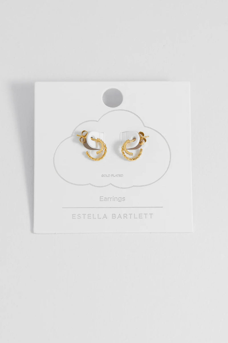 Gold hoop earrings on a white card with 'Estella Bartlett' branding.