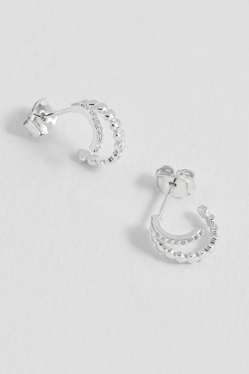 Silver hoop earrings on a light gray background