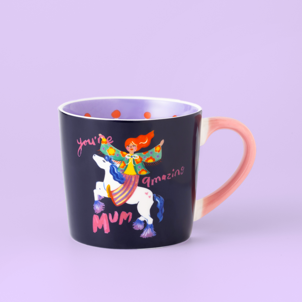 Black mug with colorful unicorn design and text on a light purple background