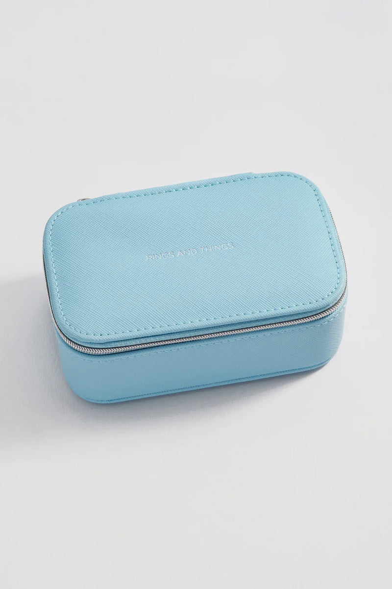 A light blue textured leather zippered case with silver-tone hardware, featuring the words Rings
and Things embossed on the front, set against a clean white background.