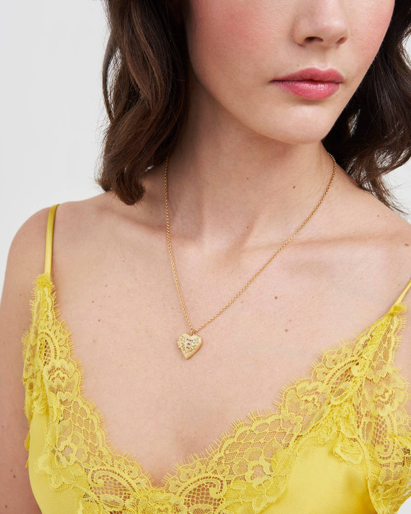 Fable Floral Heart Gold Locket Necklace on woman wearing a yellow top