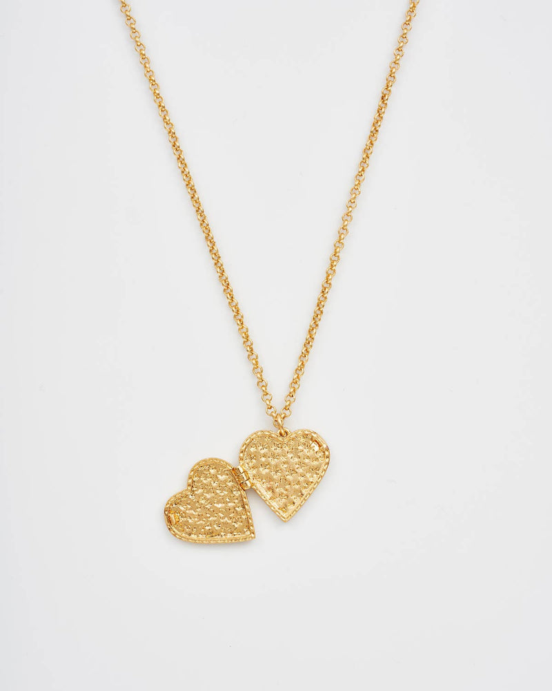 Fable England Gold necklace with two heart pendants on a light gray background