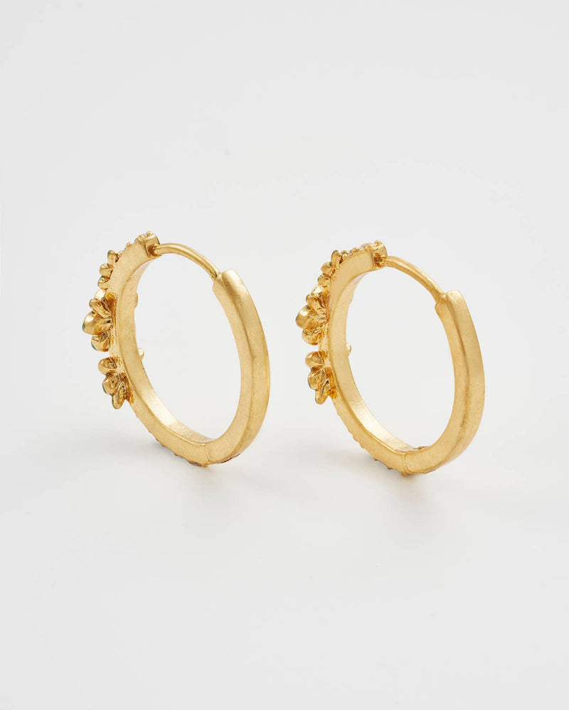 Fable England Gold hoop earrings with floral details on a light grey background