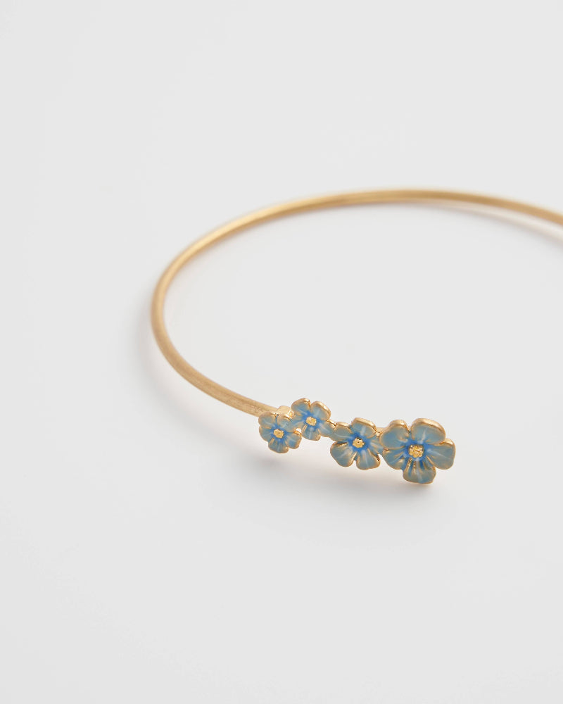 Fable Forget-Me-Not Bangle with blue floral decorations on a white background