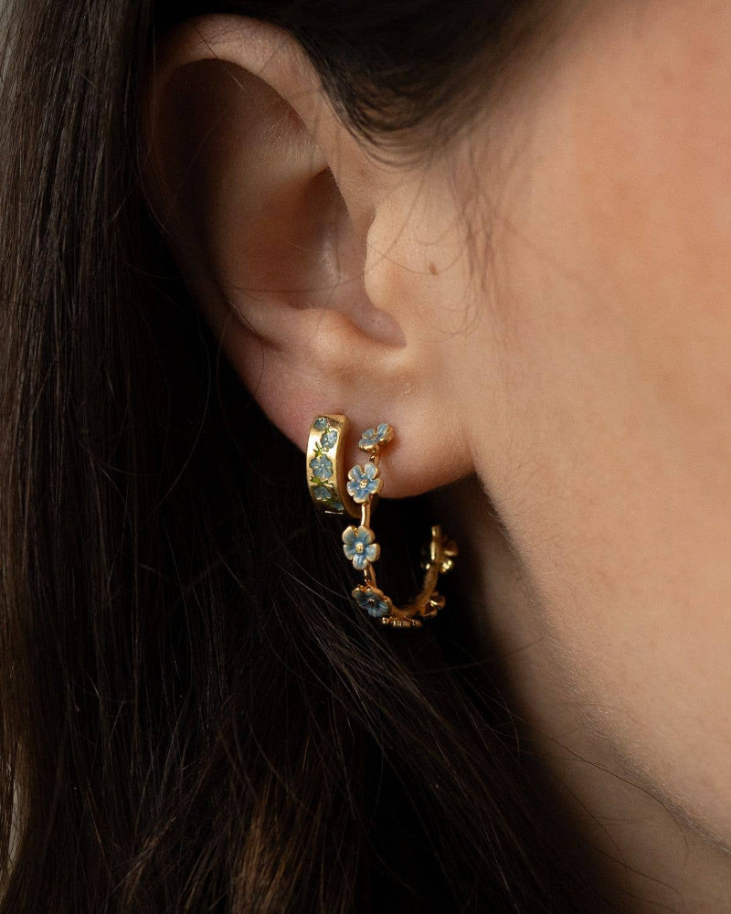 Close-up of an ear wearing Fable Forget-Me-Not Stud Hoops gold hoop earrings with gemstones.