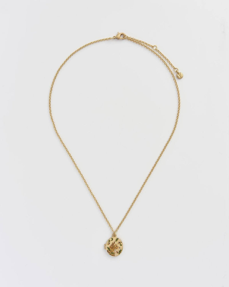 Gold necklace with a pendant on a light gray background