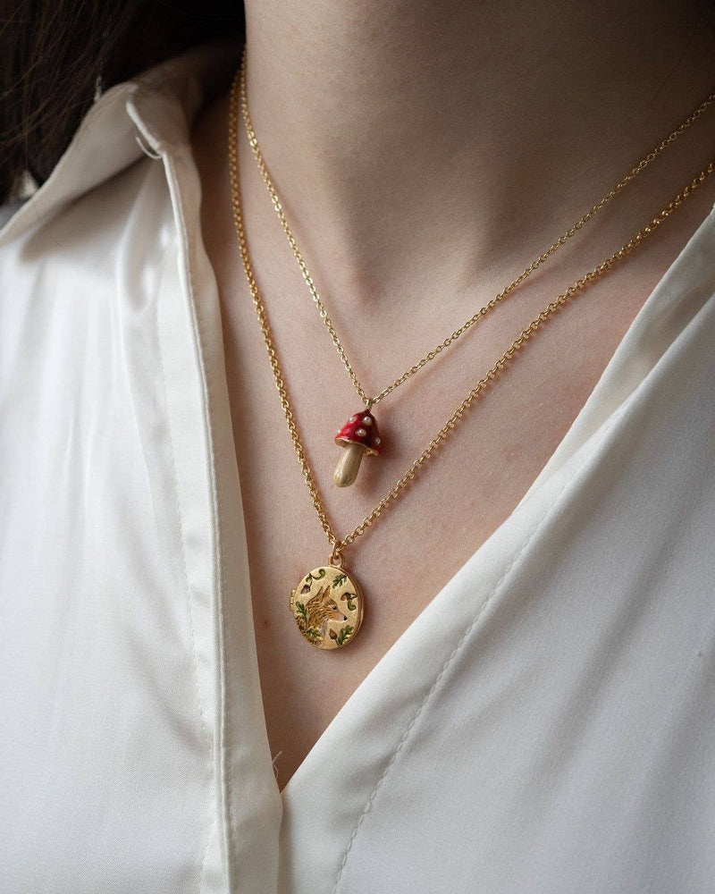 Close-up of a person wearing a Fable Fox & Acorn Oval Chain Locket Necklace