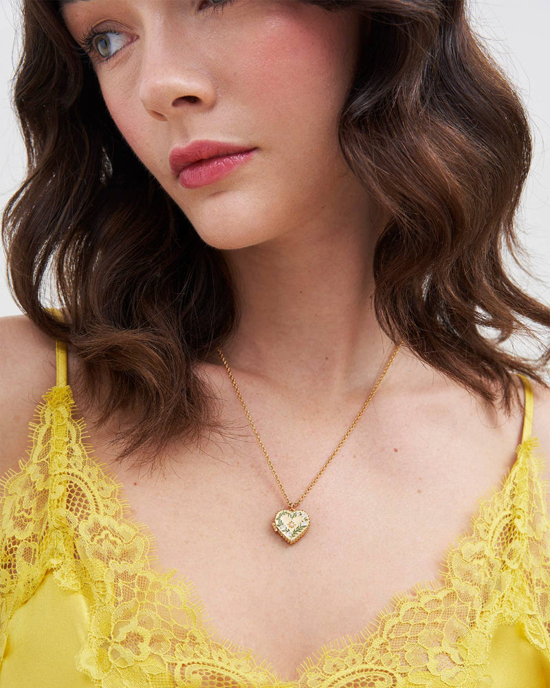 Woman wearing a yellow lace top and Fable Jasmine Heart Locket Necklace