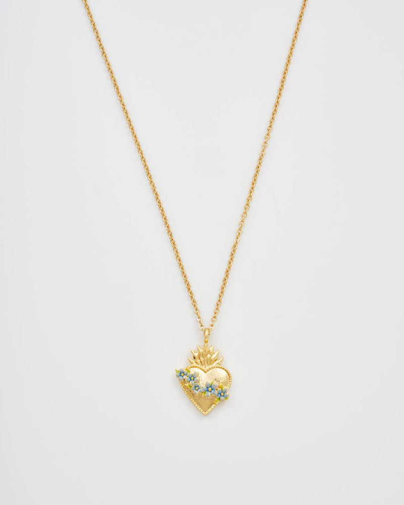 Gold heart-shaped necklace with a chain on a light gray background