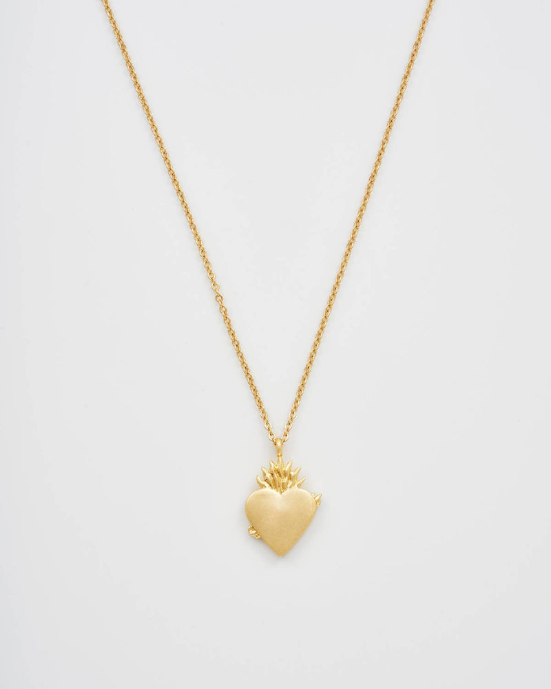 Gold heart-shaped pendant necklace on a light gray background