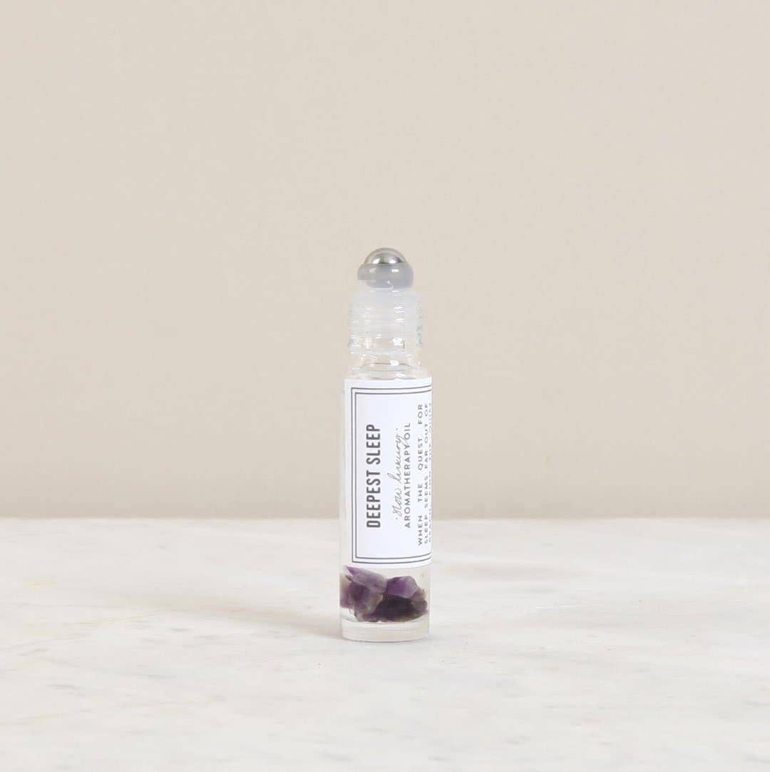 Small bottle labeled 'Deepest Sleep' with purple crystals on a beige background