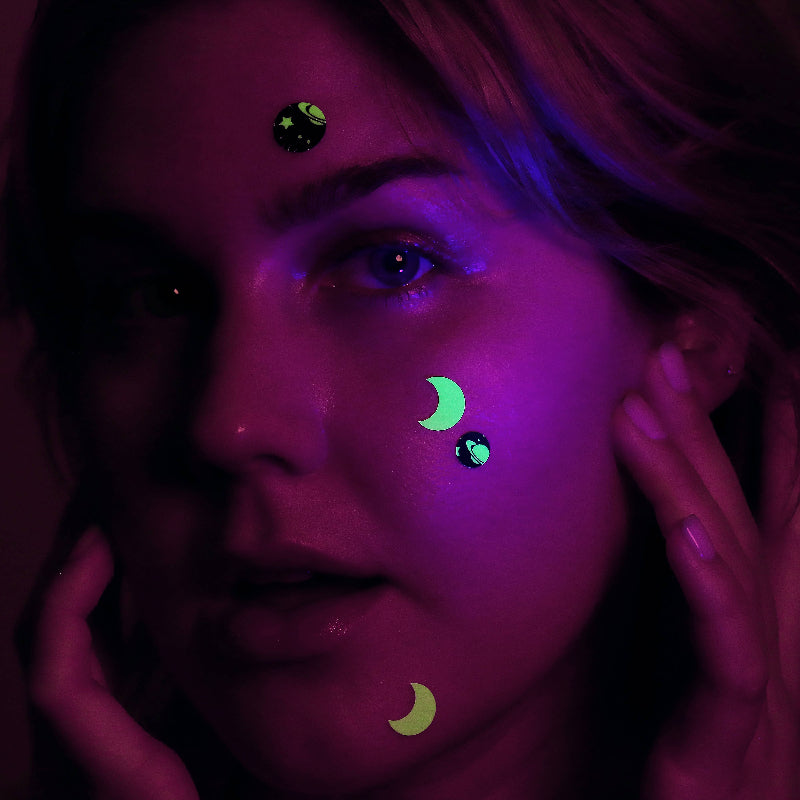 Person with glowing Glow in the Dark Hydrocolloid Pimple Patches on their face in a dark setting