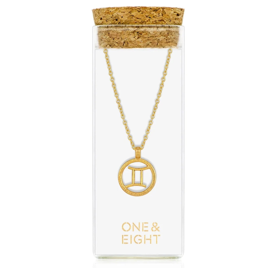 one & eight zodiac necklace in gold presented in a glass tube