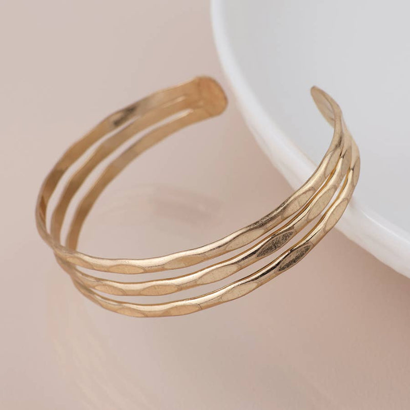 Gold bracelet on a beige background