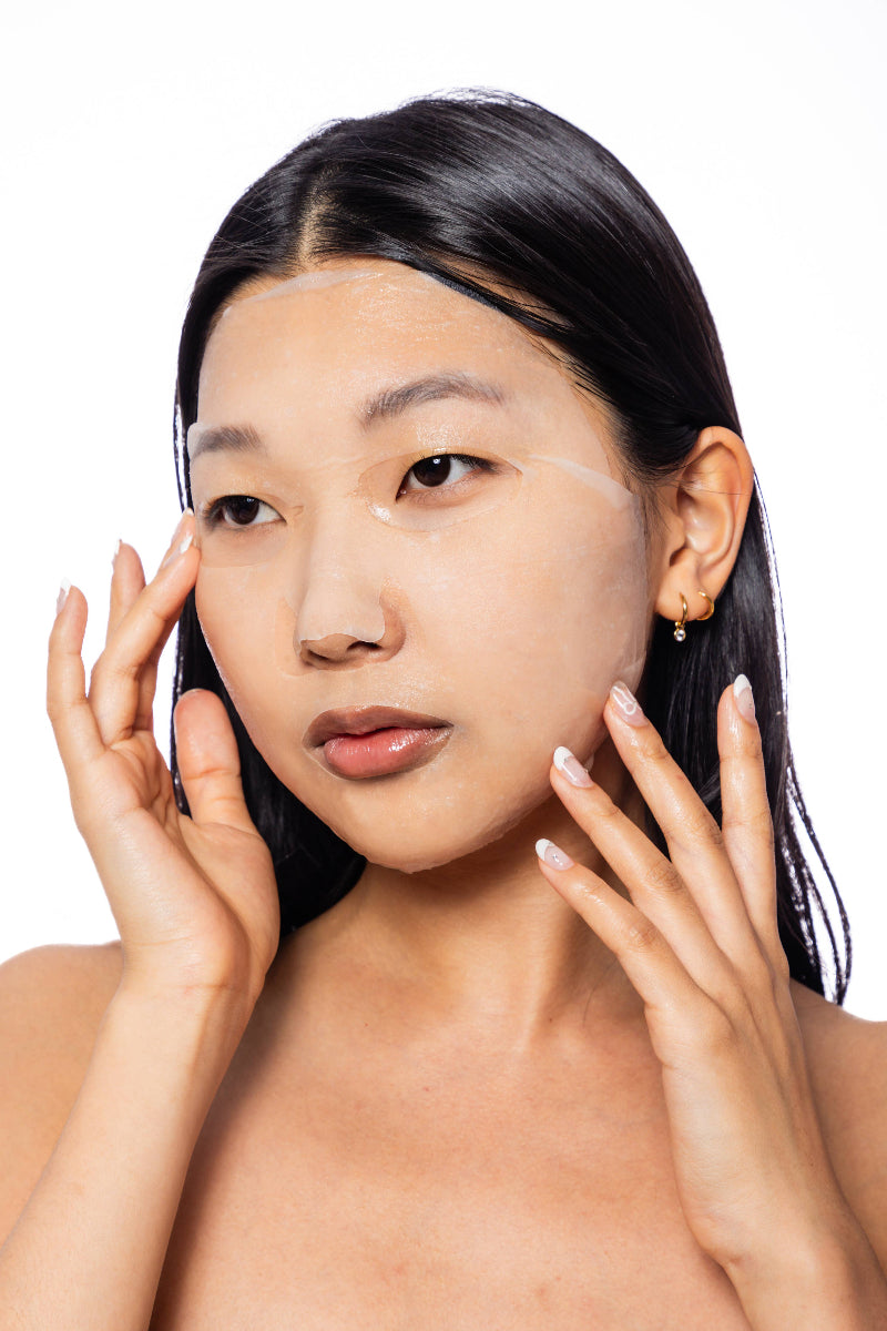 Woman with hands on face against a white background
