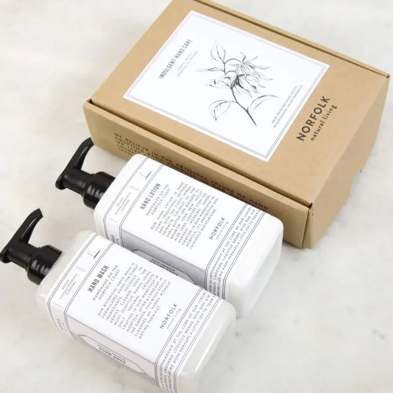 Two white bottles with black pumps and a brown box labeled 'Norfolk' on a light surface.