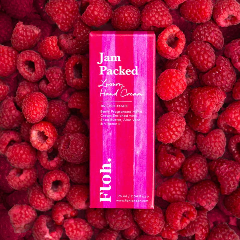 Floh Pink hand cream container labeled 'Jam Packed' surrounded by raspberries