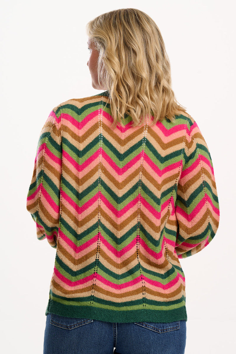 A woman wearing Sugarhill Bella Cardigan a colourful striped sweater with a white background