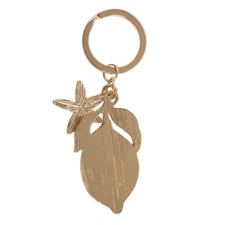 Gold keychain with leaf and starfish charms on a white background