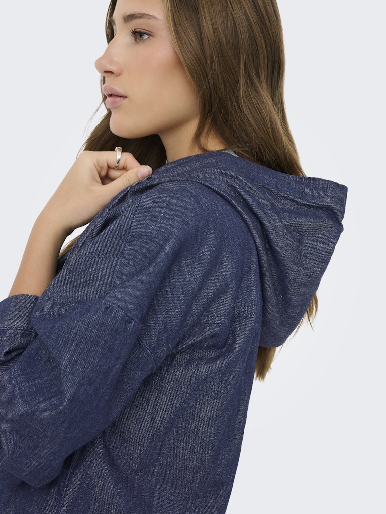 Woman wearing a blue denim jacket on a white background