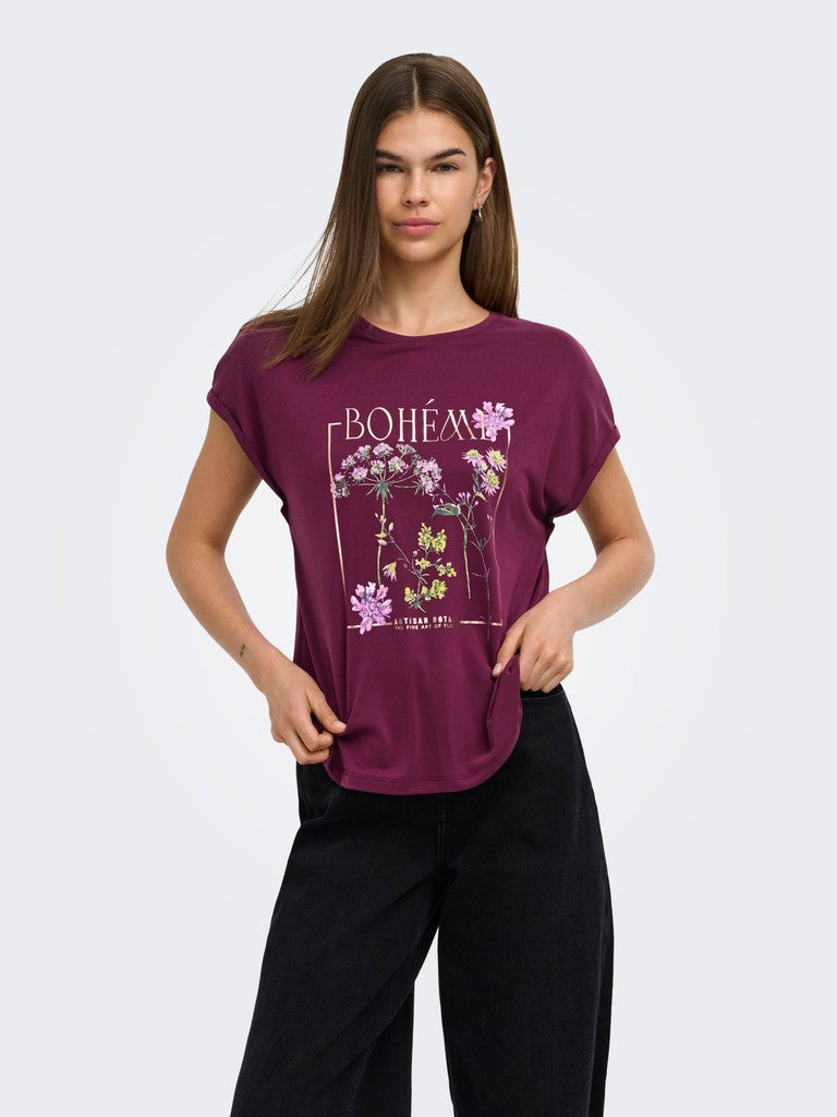 A woman modeling a short-sleeve crewneck t-shirt in deep plum purple. The shirt features a graphic print on the front with the word 'BOHEMIA' in white script above a floral illustration with purple, pink, and green elements.
