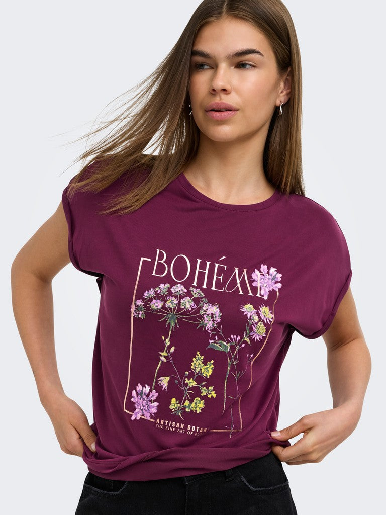 A woman wearing a short-sleeve crewneck t-shirt in deep burgundy with a botanical graphic and the word 'BOHÉM' printed on the front, paired with black jeans against a light gray studio background.