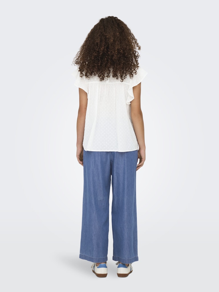 Person wearing a white top and blue pants on a white background
