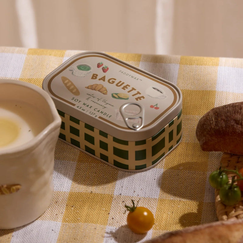 Baguette tin on a checkered tablecloth with bread and butter