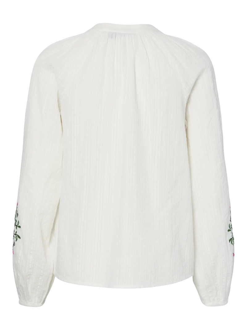 White sweater with green floral patterns on sleeves against a white background
