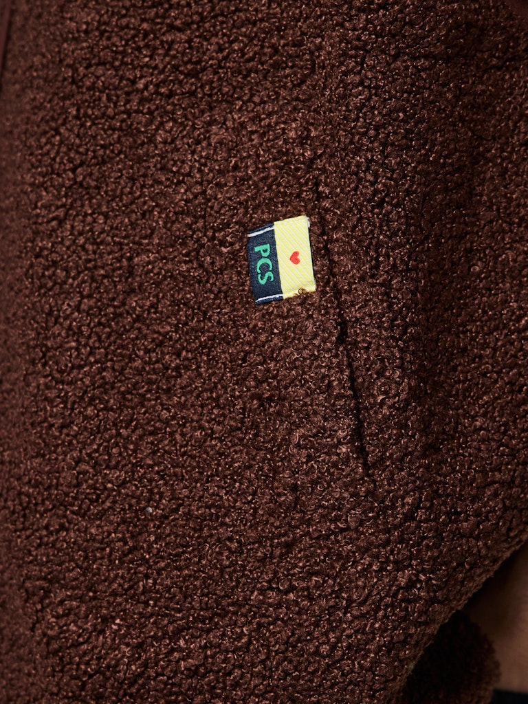 Close-up of a brown textured fabric with a small logo in the center.