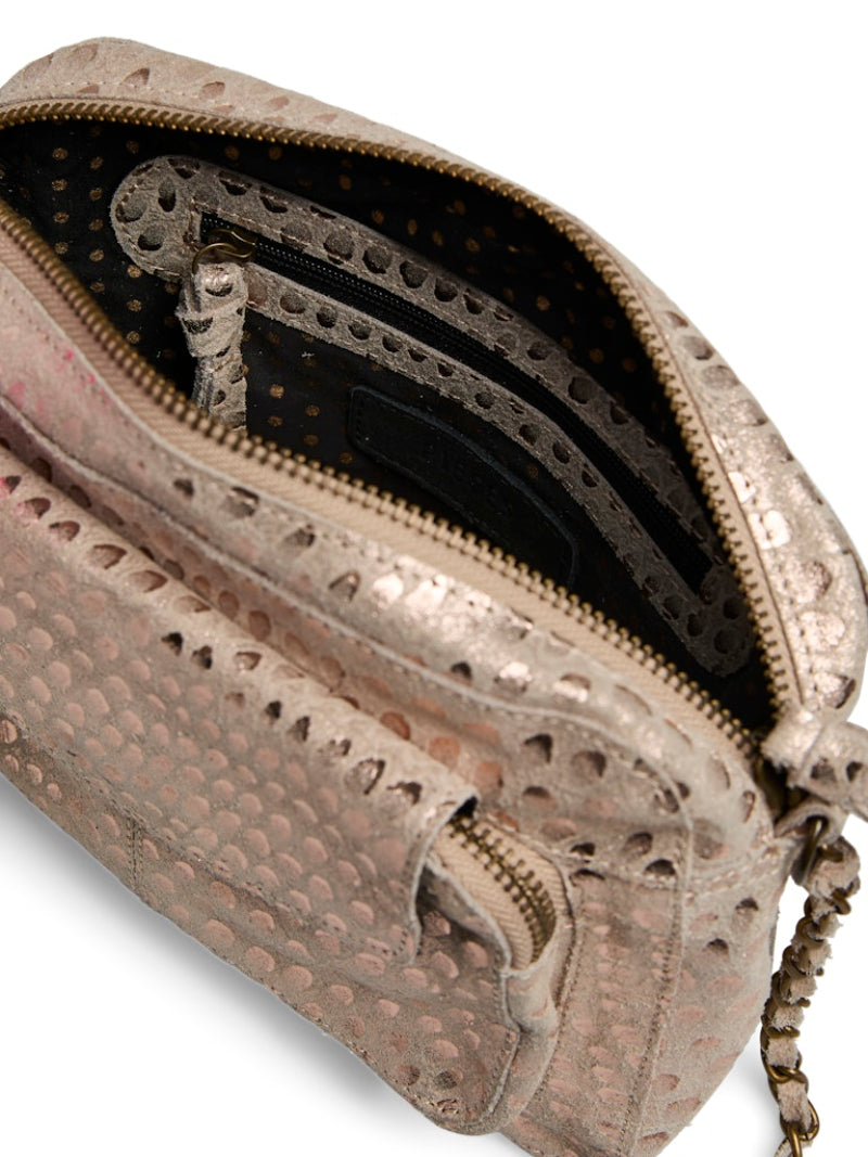 Close-up of a textured handbag with perforated design on a white background