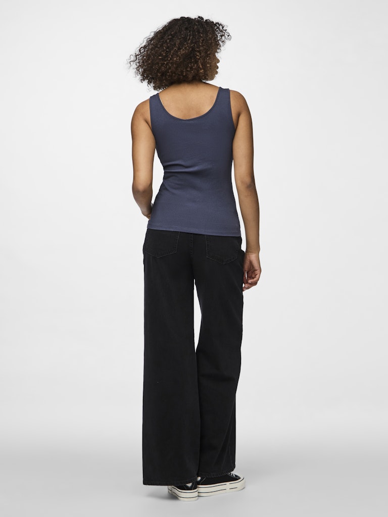 Person wearing a navy tank top and black pants on a white background