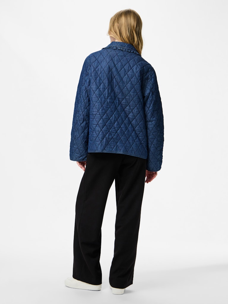 Person wearing a blue quilted jacket on a white background