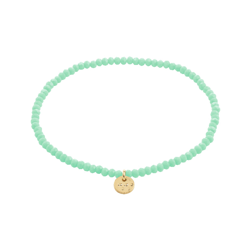 Mint green beaded bracelet with a gold charm on a white background
