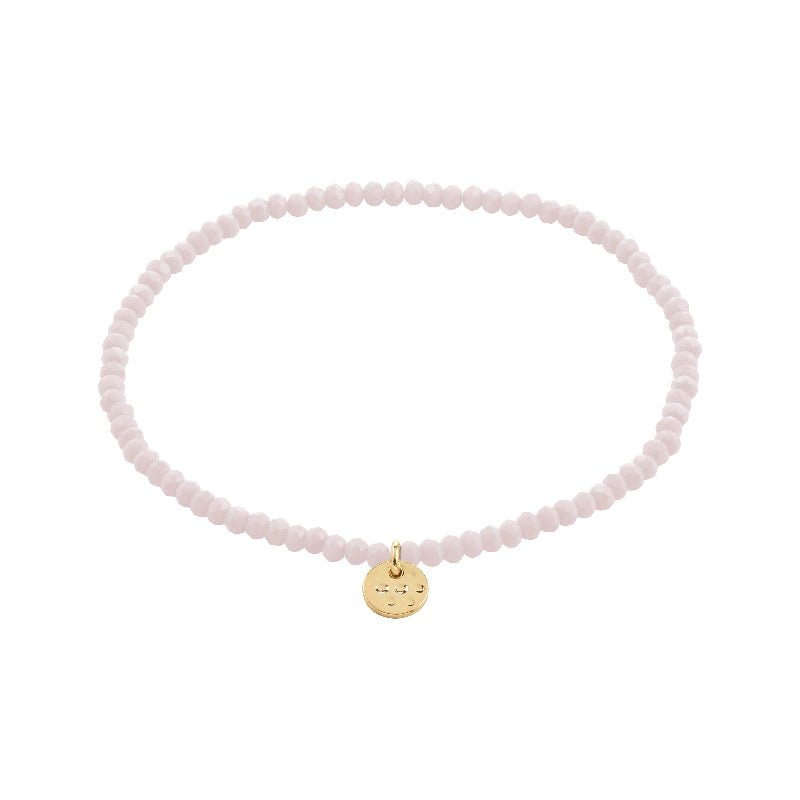 Pink beaded bracelet with a gold charm on a white background