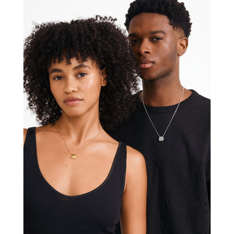 Two people wearing black tops against a white background