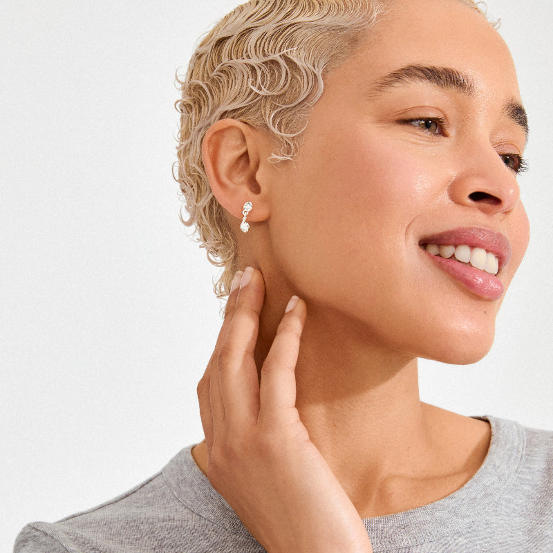 Close up of a woman wearing a silver earring on a white background
