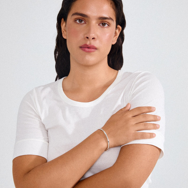 Woman wearing a white t-shirt against a plain background