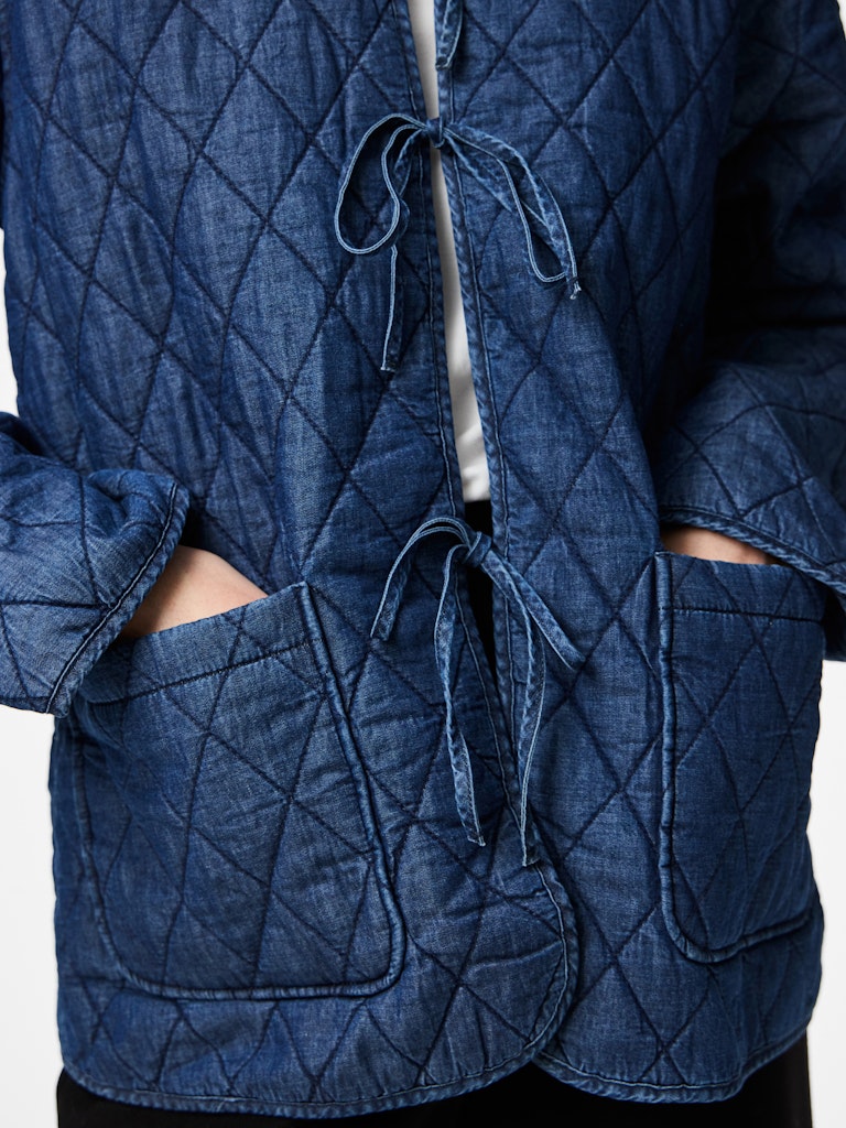 Blue quilted jacket with a white background