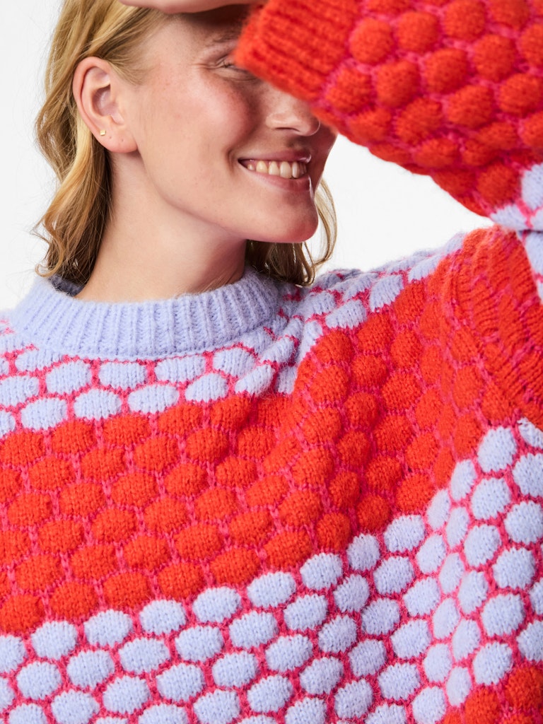 Person wearing a colorful Pieces Janel Knit Jumperwith a pattern of red, white, and blue.