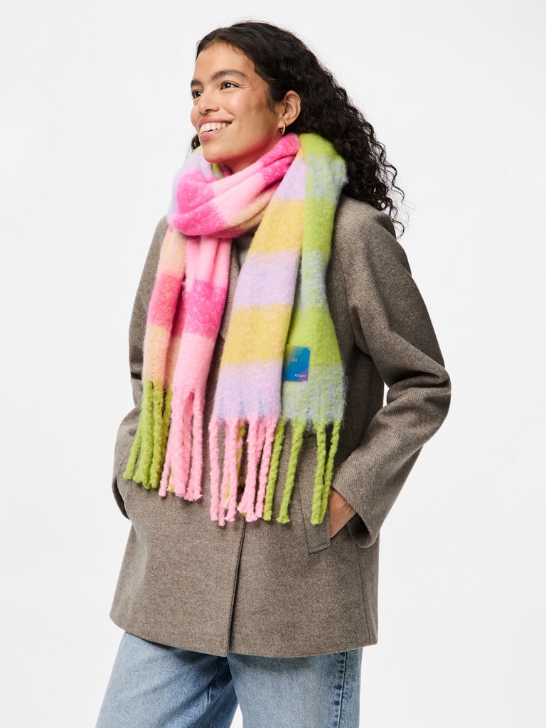 Woman wearing a colorful striped scarf with a neutral background